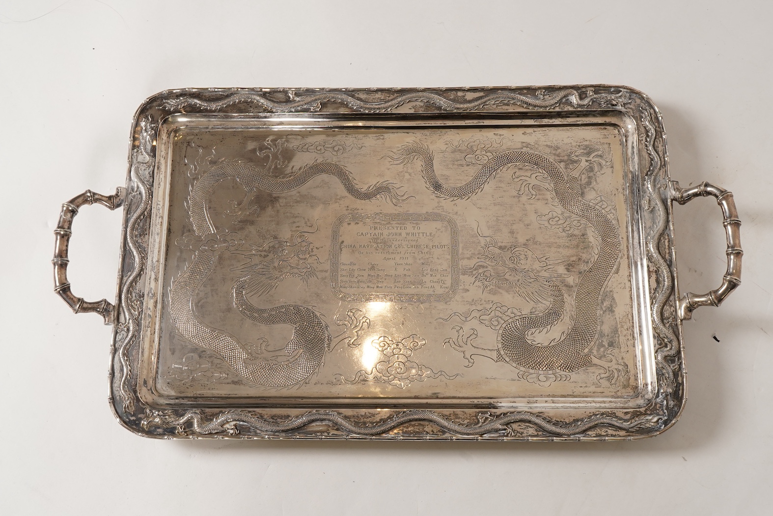 An early 20th century Chinese Export white metal two handled rectangular tea tray, by Luen Wo, Shanghai, with engraved presentation inscription, 'Presented to Captain John Whittle by the undersigned China Navigation Cos.